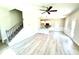 Open-concept living area showcasing wood-look floors, a ceiling fan, and a view into the kitchen at 332 Bishop Ln, Sanford, NC 27330