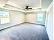 Carpeted main bedroom with a tray ceiling, fan, recessed lighting, and multiple windows at 332 Bishop Ln, Sanford, NC 27330