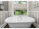 Bright bathroom featuring a soaking tub, large window, and stylish faucet at 3440 Black Bear Cv, Burlington, NC 27215