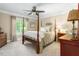 Spacious bedroom with a four-poster bed, neutral decor, and ample natural light from the window at 3440 Black Bear Cv, Burlington, NC 27215