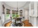 Breakfast nook with a glass-top table, chandelier, and a sunny view from the many windows at 3440 Black Bear Cv, Burlington, NC 27215