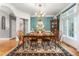 Formal dining room featuring hardwood floors, teal accent wall, and an ornate chandelier above the wood table at 3440 Black Bear Cv, Burlington, NC 27215