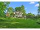 Two-story house with mature trees and an inviting wraparound porch at 3440 Black Bear Cv, Burlington, NC 27215