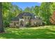 Stately brick home with manicured lawn, mature trees, and welcoming front entrance at 3440 Black Bear Cv, Burlington, NC 27215
