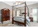 Cozy bedroom with a four poster bed, ceiling fan, and neutral colors at 3440 Black Bear Cv, Burlington, NC 27215