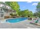 Backyard oasis with an in-ground pool, lush greenery, lounge chairs, and a charming two-story home at 3440 Black Bear Cv, Burlington, NC 27215