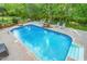 In-ground pool surrounded by lounge chairs and lush greenery, ideal for relaxation and outdoor enjoyment at 3440 Black Bear Cv, Burlington, NC 27215