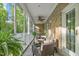 Inviting screened-in porch with stone accents, comfortable seating, a ceiling fan, and serene outdoor views at 3440 Black Bear Cv, Burlington, NC 27215