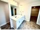Bathroom featuring double sinks, a large mirror, and entryways to the shower and walk-in closet at 356 Bishop Ln, Sanford, NC 27330
