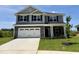 Two-story home featuring gray siding, a stone garage, and a well-manicured lawn at 356 Bishop Ln, Sanford, NC 27330