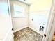 Bright laundry room features tile flooring, wire rack shelving, a window and a utility sink hookup at 356 Bishop Ln, Sanford, NC 27330