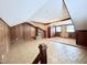 Spacious bonus room features wood paneling, brick accent, ample natural light, and unique architectural details at 3605 Mine Creek Rd, Burlington, NC 27217