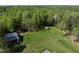 A lush, grassy yard complements this wooded lot featuring outbuildings and mature trees at 435 Salt And Light Ln, Henderson, NC 27537