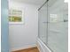 Bathroom features a combination shower/tub, blue cabinet, stained glass window at 435 Salt And Light Ln, Henderson, NC 27537