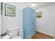 Bright bathroom featuring a light blue cabinet, toilet, and framed artwork on the wall above the toilet at 435 Salt And Light Ln, Henderson, NC 27537