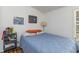 Bright bedroom with wood floors, featuring a full-size blue quilted bed and a window overlooking the outdoor scenery at 435 Salt And Light Ln, Henderson, NC 27537