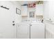 Well-lit laundry room with a white washer and dryer set, white cabinets, and a convenient side door at 435 Salt And Light Ln, Henderson, NC 27537