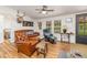 Living room featuring a ceiling fan, two windows, and comfortable leather furniture at 435 Salt And Light Ln, Henderson, NC 27537