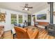 Living room featuring a wood burning stove, TV, comfortable leather furniture and two large windows at 435 Salt And Light Ln, Henderson, NC 27537