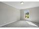 Neutral bedroom featuring gray carpet, a window, and natural lighting at 4467 Virgilina Rd, Roxboro, NC 27574