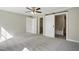 Spacious carpeted bedroom featuring a ceiling fan, closet, and bathroom access at 4467 Virgilina Rd, Roxboro, NC 27574