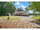 Rear exterior view of home and detached garage shows a well-manicured lawn and gravel driveway at 4467 Virgilina Rd, Roxboro, NC 27574