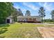 Back exterior featuring a wood deck, a detached garage, and a spacious yard at 4467 Virgilina Rd, Roxboro, NC 27574