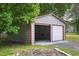 A detached, two-car garage with open doors is surrounded by mature trees at 4467 Virgilina Rd, Roxboro, NC 27574