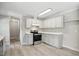 Modern kitchen featuring white cabinets, a stainless steel range, and light wood-look floors at 4467 Virgilina Rd, Roxboro, NC 27574