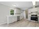 Kitchen featuring stainless steel appliances, white cabinets, and wood-look floors, with a window above the sink at 4467 Virgilina Rd, Roxboro, NC 27574