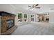 Large living room featuring a stone fireplace and three large windows overlooking the deck at 4467 Virgilina Rd, Roxboro, NC 27574
