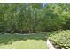 Beautiful backyard with manicured lawn, mature trees, and black metal fence at 5009 Coe Hill Pl, Cary, NC 27519