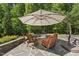 Inviting outdoor patio with stone floor, seating, and shade umbrella at 5009 Coe Hill Pl, Cary, NC 27519