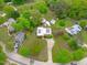 Aerial view of a home with solar panels, surrounded by lush greenery and well-maintained lawns in a quiet neighborhood at 5144 Jeffries St, Raleigh, NC 27606