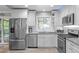 Well-lit kitchen featuring stainless steel appliances, custom cabinetry, and stylish tile backsplash at 5144 Jeffries St, Raleigh, NC 27606