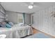 Cozy bedroom showcases a comfortable bed, wood floors, stylish wallpaper, and lots of natural light at 5144 Jeffries St, Raleigh, NC 27606