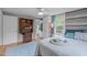 Comfortable main bedroom featuring hardwood floors, wood accent wall, updated ceiling fan, and ensuite bathroom at 5144 Jeffries St, Raleigh, NC 27606