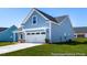 Charming blue home featuring a two-car garage and well-manicured front lawn and inviting curb appeal at 517 W Brocklyn St # 63P, Benson, NC 27504