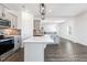 Bright open kitchen with gray cabinets, stainless appliances, island, and modern pendant lights at 517 W Brocklyn St # 63P, Benson, NC 27504