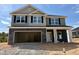 New home under construction featuring a two-car garage and stone accents at 356 Bishop Ln, Sanford, NC 27330