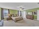 Large bedroom featuring carpet, neutral green walls, ceiling fan, and plenty of natural light at 5525 Garnet Meadow Rd, Knightdale, NC 27545