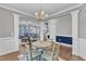 Dining room featuring decorative columns, a chandelier, and a view of the living room and stairway at 5525 Garnet Meadow Rd, Knightdale, NC 27545