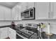 Close-up of modern kitchen features: stainless steel appliances, white subway tile, and black countertops at 5525 Garnet Meadow Rd, Knightdale, NC 27545
