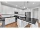 Modern kitchen with white cabinets, stainless steel appliances, and a black granite countertop island at 5525 Garnet Meadow Rd, Knightdale, NC 27545