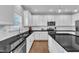 Bright, modern kitchen with white cabinets, dark countertops, stainless steel appliances, and subway tile backsplash at 5525 Garnet Meadow Rd, Knightdale, NC 27545