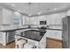 Well-lit kitchen with a central island, black countertops, stainless steel appliances and white cabinets at 5525 Garnet Meadow Rd, Knightdale, NC 27545