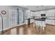 Well-lit kitchen featuring island with seating, white cabinets, and an exterior door for easy outdoor access at 5525 Garnet Meadow Rd, Knightdale, NC 27545