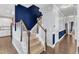 Carpeted staircase with white railings and dark accent wall, leading to upper level, and open to living spaces at 5525 Garnet Meadow Rd, Knightdale, NC 27545