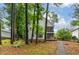 Secluded backyard with mature trees, screened porch, and gravel path at 6 Chelan Ct, Durham, NC 27713