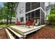Outdoor patio with furniture and a screened-in porch surrounded by lush trees in the backyard at 6 Chelan Ct, Durham, NC 27713